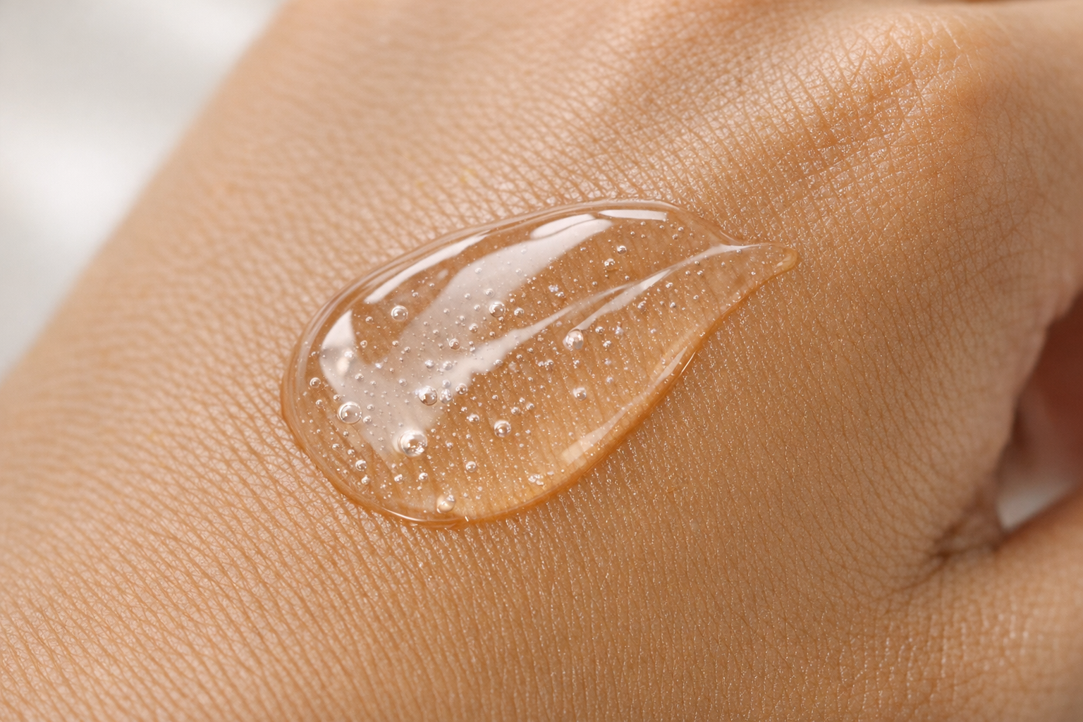 Close-up of a clear, gel-like face serum texture on a hand