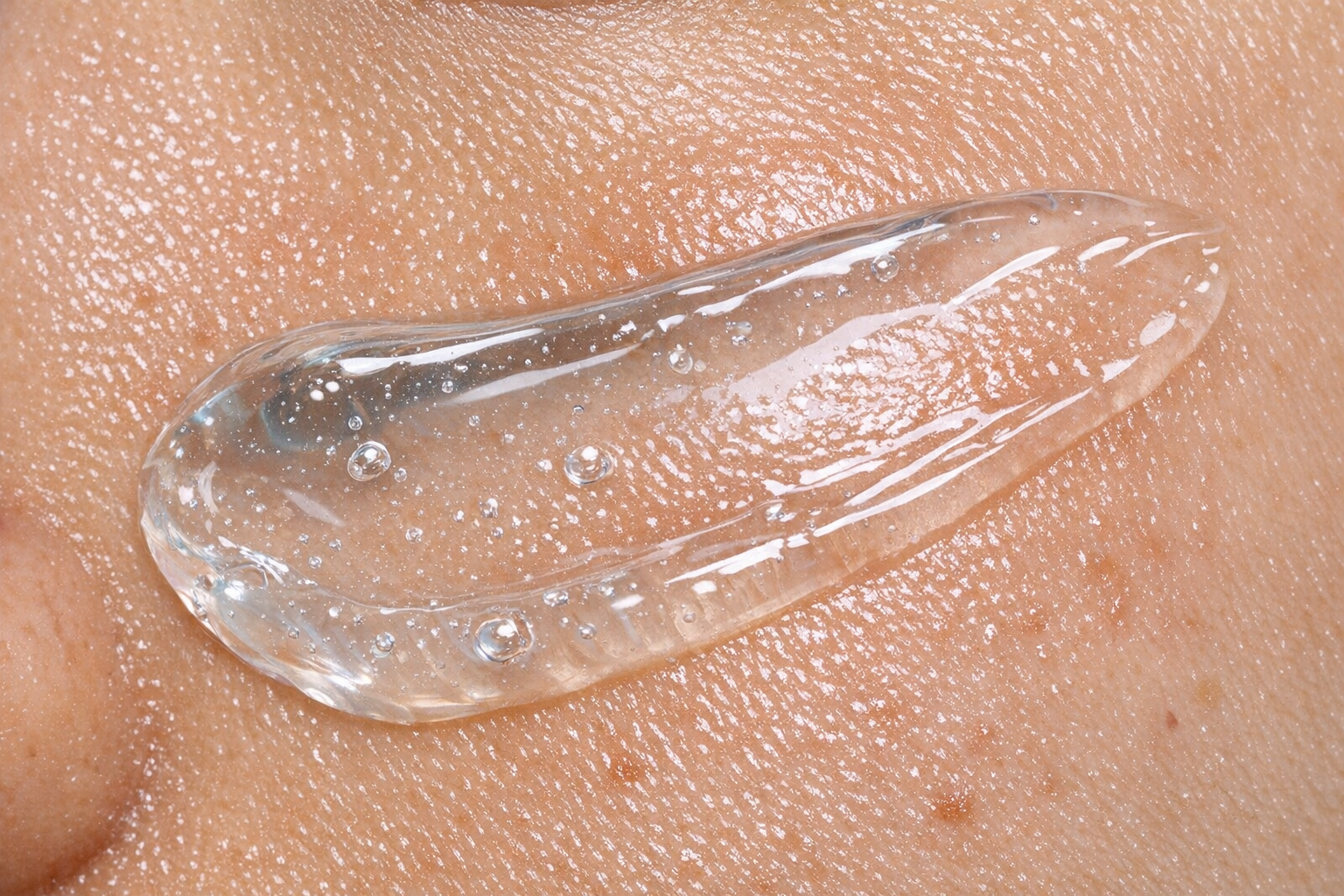 Close-up of a clear lightweight night gel texture applied on oily skin