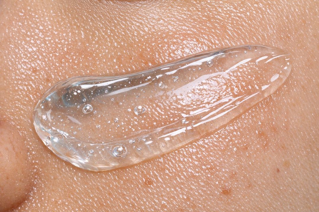 Close-up of a clear lightweight night gel texture applied on oily skin