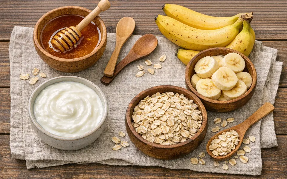 Bowls of honey, curd, oats, and banana arranged on a table for DIY dry-skin face masks