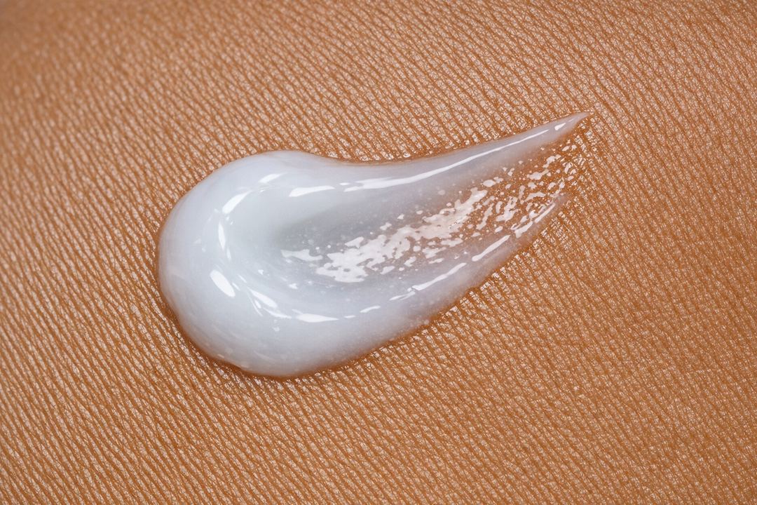 Close-up of a lightweight gel-cream moisturizer texture on medium-brown Indian skin