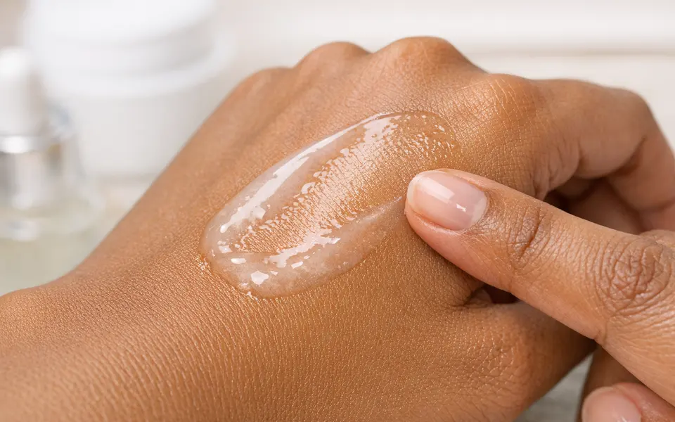 Close-up of a lightweight serum texture being tested on the back of an Indian woman’s hand
